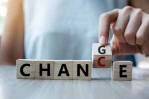 Image intended to articulate change leadership. Wooden blocks spell out the word "change". A woman flips the G to become a C, articulating the chance or opportunity that comes with change.